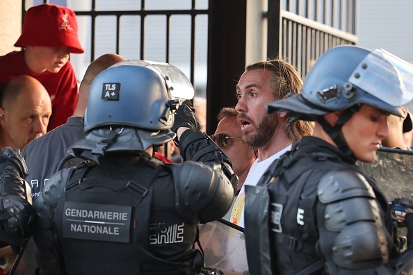 La police se tient devant les fans avant le match de football de la finale de la Ligue des champions de l'UEFA entre Liverpool et le Real Madrid au Stade de France à Saint-Denis, au nord de Paris, le 28 mai 2022. (Photo : THOMAS COEX/AFP via Getty Images)