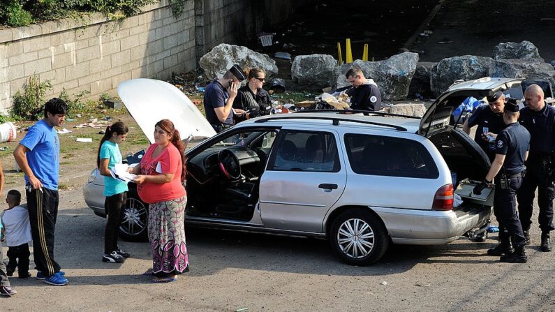 La police française fouille une voiture dans un camp de Roms, le 1er octobre 2013 à Roubaix, dans le nord de la France. Le Premier ministre français Jean-Marc Ayrault a estimé le 1er octobre 2013 à l'Assemblée nationale qu'il n'y avait "aucune raison d'exacerber" la question des Roms et a jugé possible "l'intégration" de ce peuple dès lors qu'il respecte "les lois de la République » (PHILIPPE HUGUEN/AFP via Getty Images)