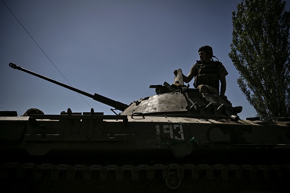 Un membre des troupes ukrainiennes se tient debout sur un véhicule blindé se dirigeant vers la ligne de front dans la ville de Lysychansk, dans la région de Donbas, dans l'est de l'Ukraine, le 9 juin 2022. (Photo : ARIS MESSINIS/AFP via Getty Images)