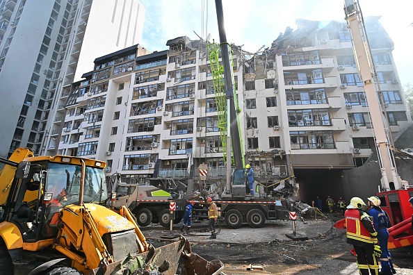 Des sauveteurs ukrainiens travaillent à l'extérieur d'un immeuble résidentiel touché par des missiles  à Kiev, le 26 juin 2022. (Photo :SERGEI SUPINSKY/AFP via Getty Images)