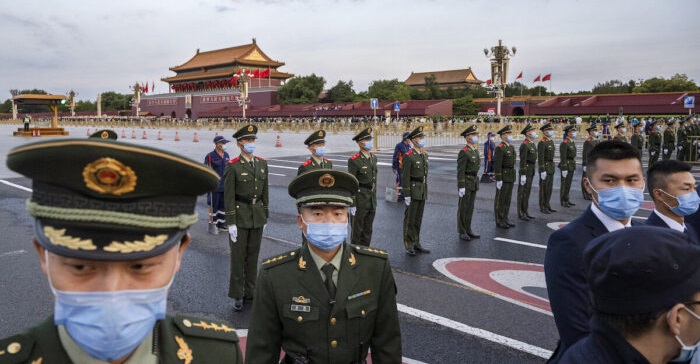 Policiers et agents de sécurité contrôlant la foule après une cérémonie officielle de lever du drapeau à l’occasion de la fête nationale le 1er octobre 2021, aux abords de la cité interdite. (Kevin Frayer/Getty Images)