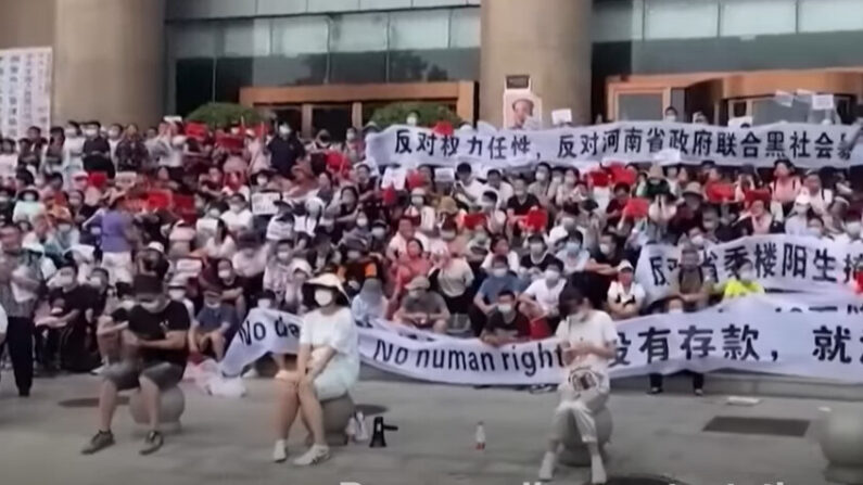 Manifestants devant la succursale de la banque centrale de Chine à Zhengzhou, dans la province du Henan. La foule nombreuse des déposants en colère a affronté la police ce 10 juillet. Certains ont été blessés puis brutalement emmenés. L’affaire avait déjà attiré l'attention en raison des tentatives antérieures du régime d'utiliser l’application contre le Covid pour empêcher les déposants de se mobiliser. (Capture d’écran NTD) 