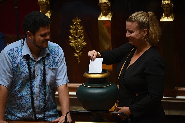 Mathilde Panot (R) députée du parti français de gauche La France Insoumise (LFI), aux côtés de Tematai Le Gayic, député du parti indépendantiste Le Tavini Polynésie, lors du vote pour le nouveau président de l'Assemblée nationale. (Photo CHRISTOPHE ARCHAMBAULT/AFP via Getty Images)