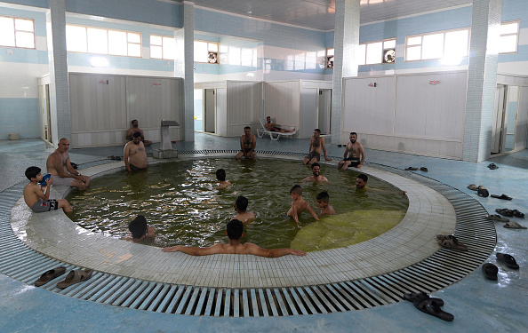 Des hommes se rassemblent aux bains de Hammam al-Alil, au sud de la ville de Mossoul, dans le nord de l'Irak, le 30 juin 2022. Photo de ZAID AL-OBEIDI/AFP via Getty Images.