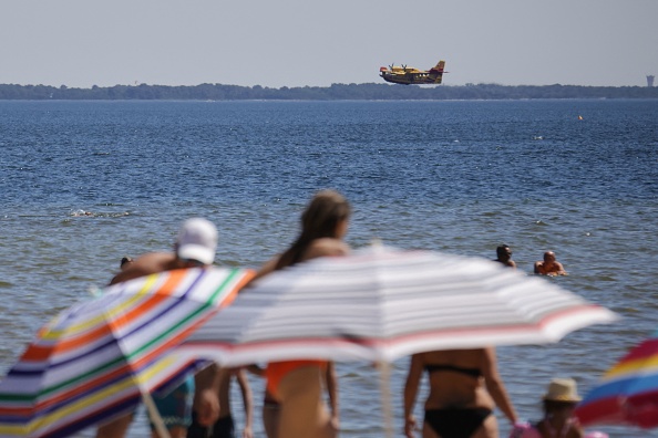 Un Canadair CL 415 est sur le point de remplir son réservoir sur le lac de Cazaux, afin d'éteindre l'incendie de La-Teste-de-Buch le 13 juillet 2022. (THIBAUD MORITZ/AFP via Getty Images)