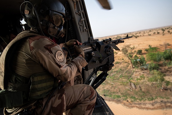 -Un militaire de la force Barkhane dans un hélicoptère, vole près de la base militaire de Ouallam, le 15 juillet 2022. Photo de BERTRAND GUAY/AFP via Getty Images.