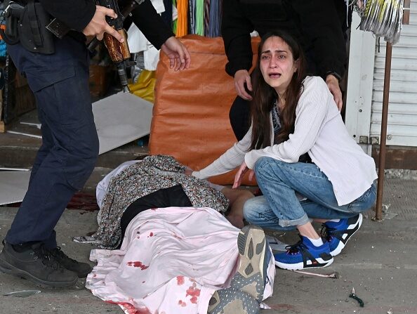 -Une femme en état de choc près du corps de son mari décédé lors d'une frappe à la roquette russe dans l'un des quartiers de la deuxième plus grande ville ukrainienne de Kharkiv le 21 juillet 2022. Photo de SERGEY BOBOK/AFP via Getty Images.