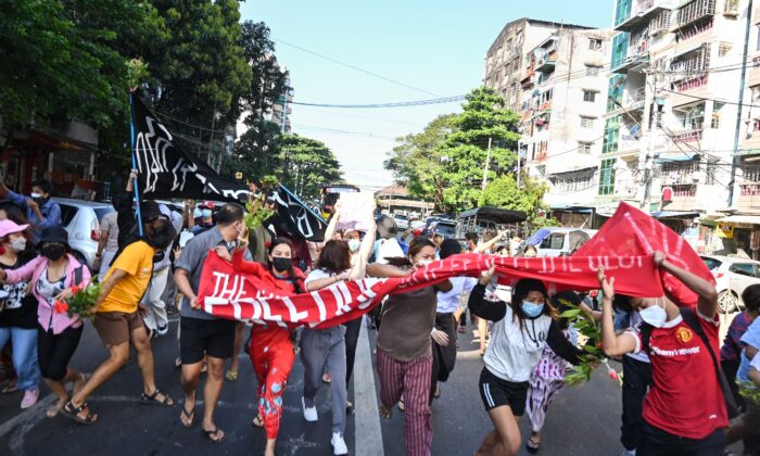 Des manifestants contre le coup d'État militaire courent alors que les forces de sécurité lancent une attaque contre leur manifestation à Yangon, en Birmanie, le 5 décembre 2021. (STR/AFP via Getty Images)