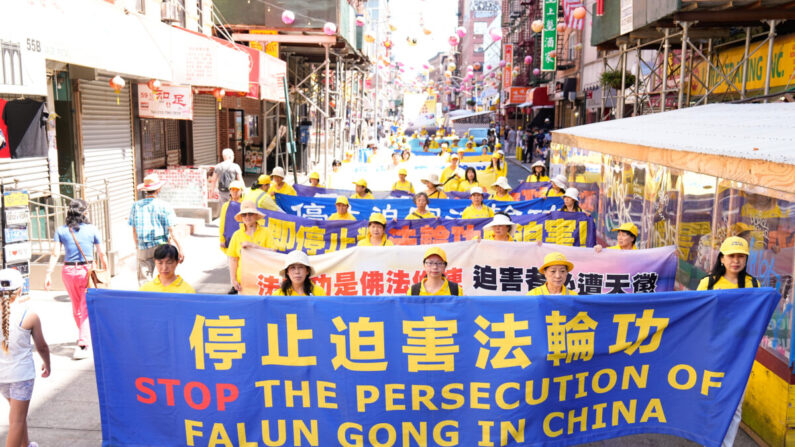 Des pratiquants de Falun Gong participent à un défilé pour commémorer le 23e anniversaire de la persécution de cette discipline spirituelle en Chine, dans le quartier chinois de New York, le 10 juillet 2022. (Larry Dye/Epoch Times)