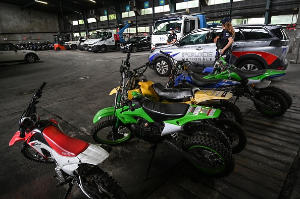 Des policiers français montent la garde à côté de motos saisies par la police après des "rodéos" urbains.  (PHILIPPE DESMAZES/AFP via Getty Images)