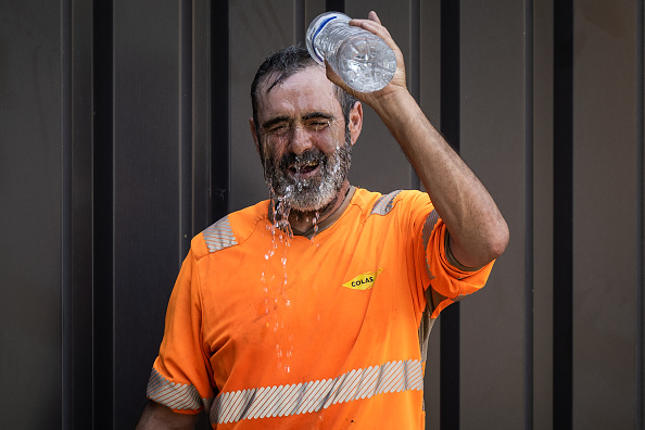 Un ouvrier se rafraîchit à l'eau sur un chantier de construction à Savenay, près de Nantes.
 (Photo LOIC VENANCE/AFP via Getty Images)