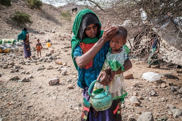 Une femme déplacée lave le visage d'un enfant dans le camp de fortune où ils sont hébergés dans le village d'Erebti, en Ethiopie, le 09 juin 2022. Photo par EDUARDO SOTERAS/AFP via Getty Images.