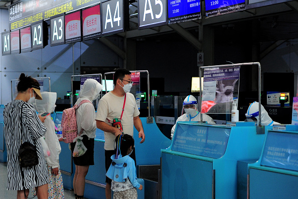 Des touristes effectuent les formalités avant le départ à l'aéroport de Sanya Phénix, sur l'île de Hainan, le 9 août 2022. (Photo: STR/AFP via Getty Images)