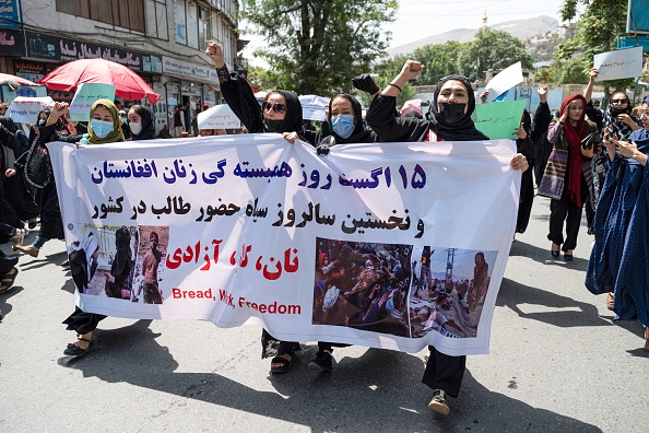 Des femmes afghanes tiennent des pancartes alors qu'elles défilent et crient des slogans "Pain, travail, liberté" lors d'une manifestation pour les droits des femmes à Kaboul le 13 août 2022. Photo de WAKIL KOHSAR/AFP via Getty Images.