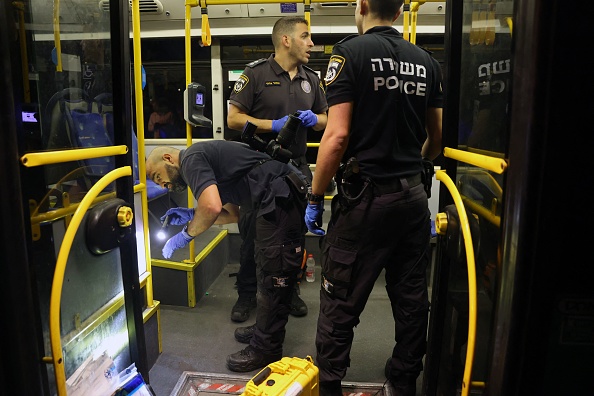 La sécurité israélienne inspecte un bus après une attaque à l'extérieur de la vieille ville de Jérusalem, le 14 août 2022. Photo AHMAD GHARABLI/AFP via Getty Images.