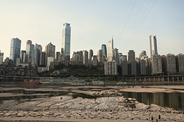 Des gens sont vus dans le lit asséché de la rivière Jialing, un affluent du fleuve Yangtze dans la ville de Chongqing, dans le sud-ouest de la Chine, le 25 août 2022. Photo de Noel CELIS/AFP via Getty Images.