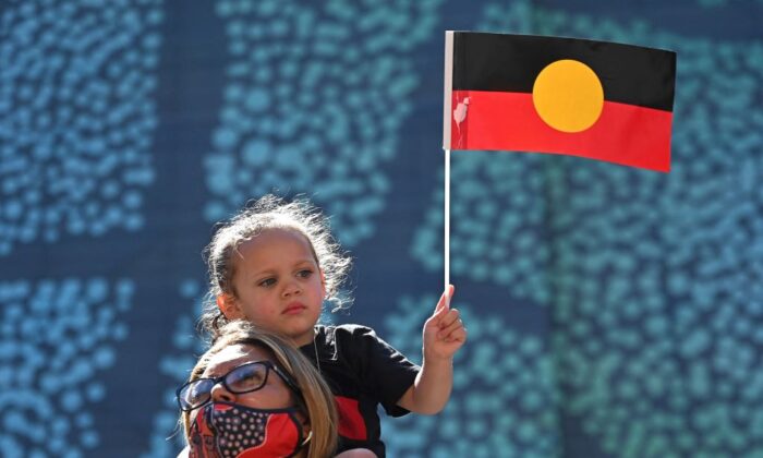 Une jeune fille brandit un drapeau aborigène australien lors de l'Australia Day à Sydney, le 26 janvier 2022. (Steven Saphore/Getty Images)