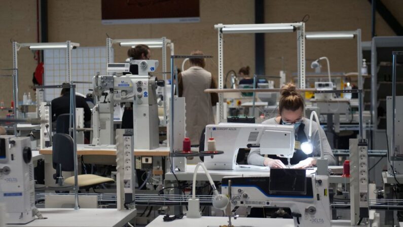 Des employés travaillent sur des sacs dans l'atelier Louis Vuitton nommé "L'Oratoire" lors de son inauguration le 22 février 2022 à Azé, près de Vendôme, dans le centre de la France. (Photo by GUILLAUME SOUVANT/AFP via Getty Images)