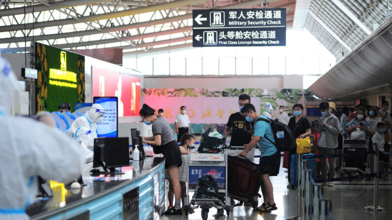 Des touristes effectuent les formalités de pré-départ à l'aéroport de Sanya Phoenix, le 9 août 2022. (Photo by STR/AFP via Getty Images)