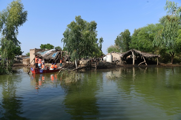 Des volontaires de la Charity Al-Khidmat Fondation utilisent un bateau pour distribuer du matériel de, le 31 août 2022. Photo par ASIF HASSAN/AFP via Getty Images.