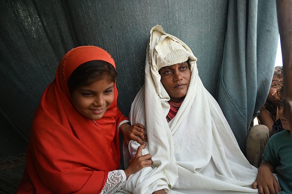 Fahmidah une femme enceinte touchée par les inondations est assise avec sa fille dans un camp de fortune le long d'une voie ferrée à Fazilpur, le 3 septembre 2022. Photo par Arif ALI / AFP via Getty Images.