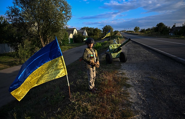 Un enfant ukrainien tient un faux fusil alors qu'il tient un poste de contrôle improvisé dans la région de Donetsk en Ukraine, le 8 septembre 2022. Photo de Juan BARRETO / AFP via Getty Images.