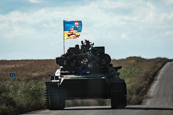 Un char ukrainien roule avec un drapeau représentant l'Ukraine et les drapeaux américains se serrant la main, dans la région de Kharkiv, le 19 septembre 2022. Photo de YASUYOSHI CHIBA/AFP via Getty Images.