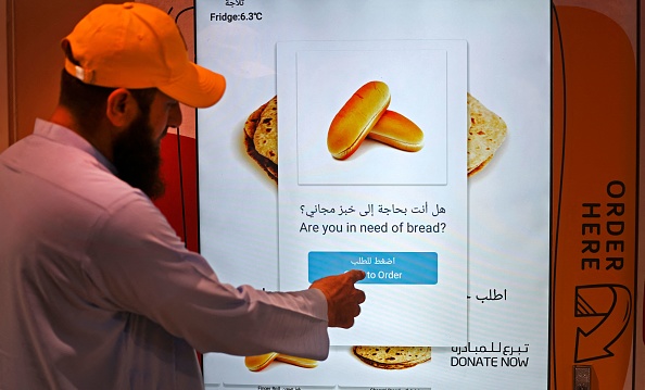 Un homme commande à un distributeur automatique du pain gratuit, à Dubaï, le 22 septembre 2022. Photo de Karim SAHIB / AFP via Getty Images.