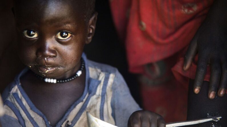 Un garçon mange à la louche dans sa maison de Ngop, dans l'État d'Unité du Soudan du Sud, le 10 mars 2017 (ALBERT GONZALEZ FARRAN/AFP via Getty Images)