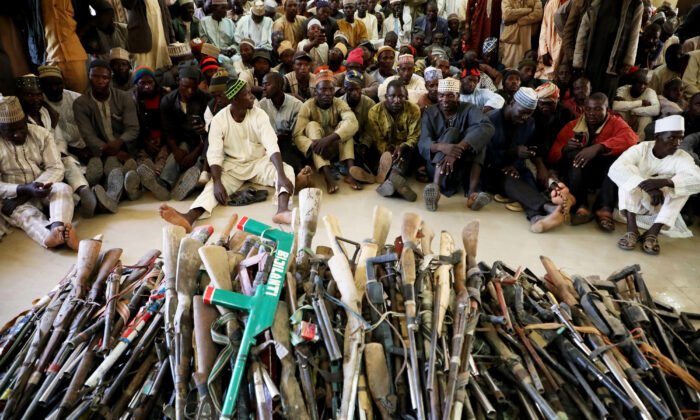 Des membres du groupe d'autodéfense Yansakai sont assis à l'intérieur d'un auditorium au siège du gouvernement de l'État de Zamfara, alors que leurs membres ont remis plus de 500 armes au gouverneur Bello Matawalle, dans le cadre des efforts visant à accepter le processus de paix du gouvernement de l'État à Gusau, le 3 décembre 2019. (Kola Sulaimon/ AFP via Getty Images)