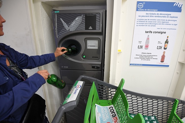 Un client dépose des bouteilles en verre consignées vides dans un dispositif dans un hypermarché de Mundolsheim, dans l'est de la France, le 30 avril 2019. (PATRICK HERTZOG/AFP via Getty Images)