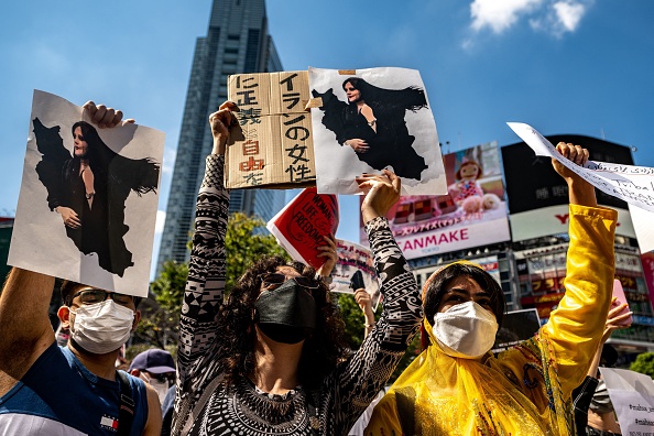 Les gens scandent des slogans et tiennent les photos de Mahsa Amini lors de l'événement "Rassemblement pour la liberté pour l'Iran" dans le district de Shibuya à Tokyo le 1er octobre 2022. Photo de Philip FONG / AFP via Getty Images.