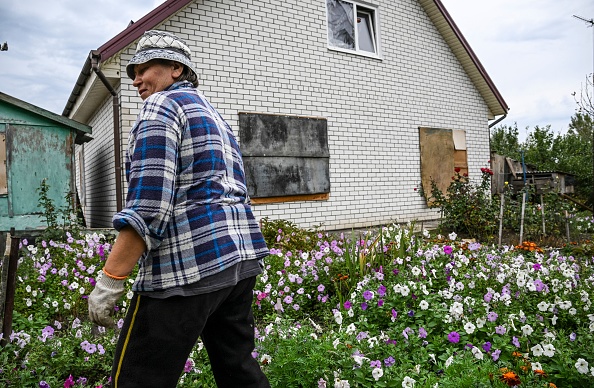 Ludmila Omelchenko marche devant son jardin dans l'est de l'Ukraine, le 2 octobre 2022, la reprise par l'Ukraine de la ville clé de l'est de Lyman signifiait qu'elle pouvait dormir à l'étage pour la première fois en sept mois. Photo de JUAN BARRETO/AFP via Getty Images.