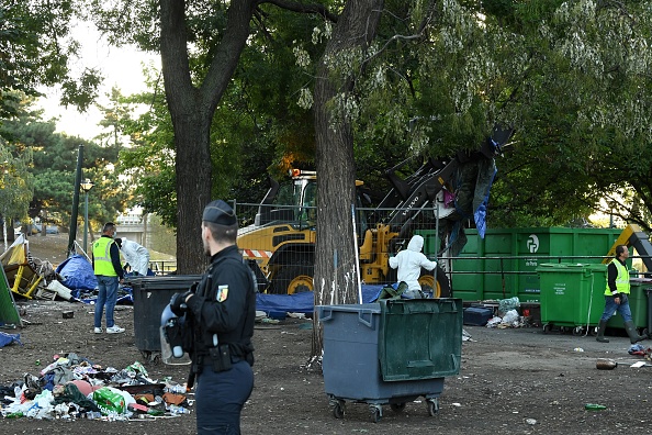 Des ouvriers municipaux nettoient la place du jardin Forceval lors du démantèlement d'un camp de drogués au crack, au nord-est de Paris, le 5 octobre 2022.  (BERTRAND GUAY/AFP via Getty Images)