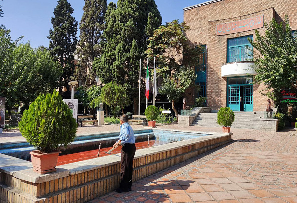 Le 7 octobre 2022 un homme regarde l'eau colorée en rouge pour protester contre une répression meurtrière de trois semaines de manifestations déclenchées en Iran. Photo par -/AFP via Getty Images.