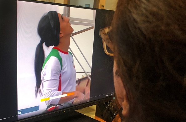 Une femme regarde un écran affichant une vidéo d'une compétition internationale d'escalade à Séoul, en Corée du Sud, durant laquelle la grimpeuse iranienne Elnaz Rekabi concourt sans voile, le 18 octobre 2022. (Photo : -/AFP via Getty Images)