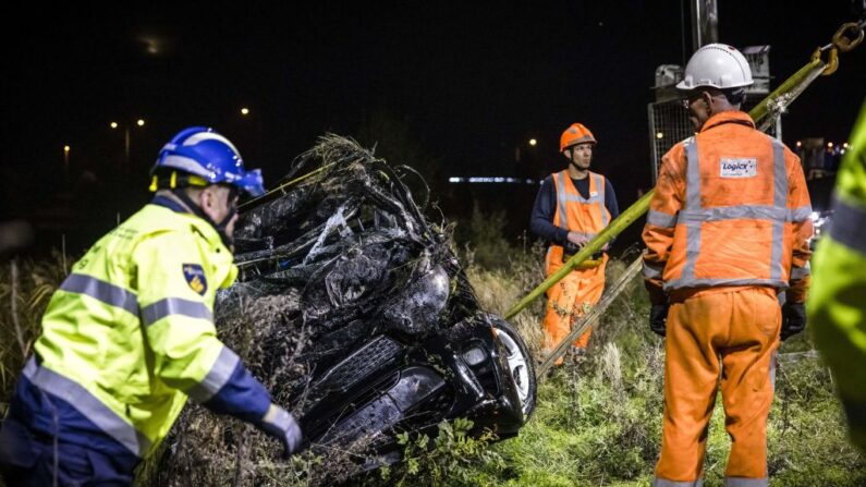 Un officier de police se tient à côté d'une voiture qui a été retrouvée dans l'eau, avec deux corps à l'intérieur, le 20 octobre 2022. (Photo by ROB ENGELAAR/ANP/AFP via Getty Images)