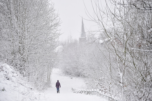 Une dame marche dans la neige devant l'église Silverdale le 29 décembre 2020 à Newcastle-Under-Lyme, en Angleterre. Photo de Nathan Stirk/Getty Images.