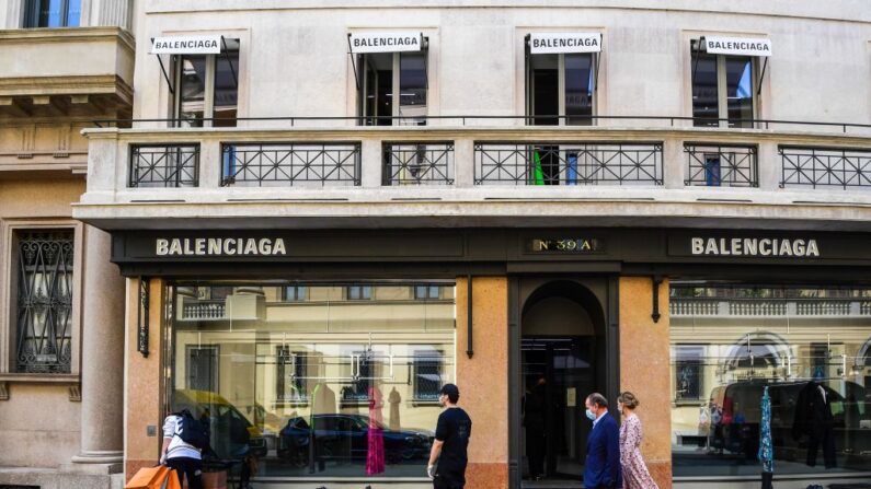 Des personnes passent devant un magasin de produits de luxe Balenciaga, le 18 mai 2020, dans le centre de Milan. (Photo: MIGUEL MEDINA/AFP via Getty Images)