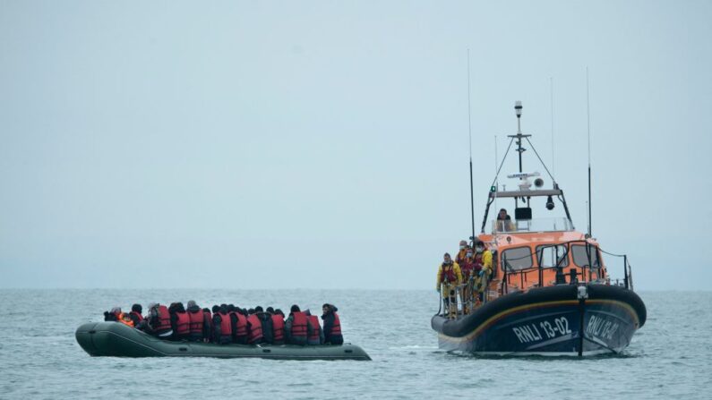 Des migrants sont aidés par un bateau de la RNLI (Royal National Lifeboat Institution) avant d'être emmenés sur une plage à Dungeness, sur la côte sud-est de l'Angleterre, le 24 novembre 2021, après avoir traversé la Manche.(Photo: BEN STANSALL/AFP via Getty Images)