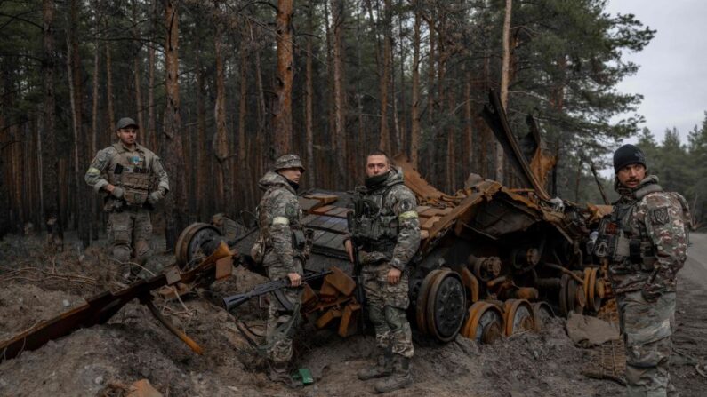 Des soldats ukrainiens et des combattants volontaires inspectent un char russe détruit, dans l'est de l'Ukraine, le 10 novembre 2022. (Photo: BULENT KILIC/AFP via Getty Images)