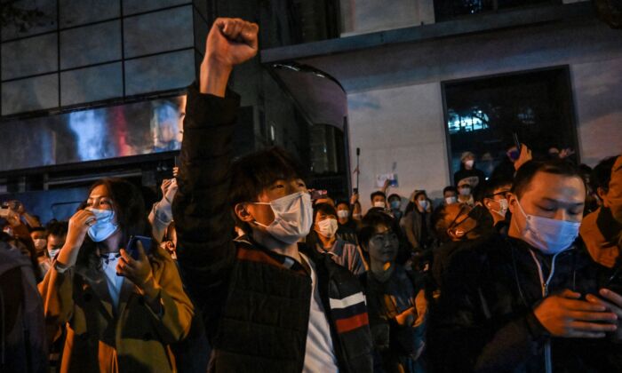 Des gens scandent des slogans en se rassemblant dans une rue de Shanghai, le 27 novembre 2022 (Hector Retamal/AFP via Getty Images).