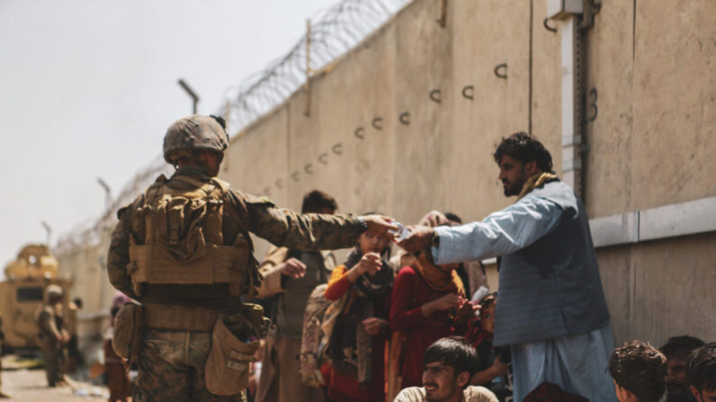 Un Marine américain distribue de l'eau au cours de l'évacuation organisée à l'aéroport international Hamid Karzai de Kaboul, en Afghanistan, le 21 août 2021. (U.S. Marine Corps/Isaiah Campbell/Getty Images)