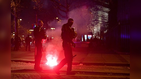 Des policiers passent sur les Champs-Élysées à Paris, le 14 décembre 2022, après la victoire de la France sur le Maroc en demi-finale de la Coupe du monde Qatar 2022. (Photo par JULIEN DE ROSA/AFP via Getty Images)