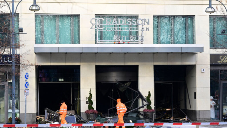 Des travailleurs du service de nettoyage passent devant des débris, le 16 décembre 2022 à Berlin. (Photo: JOHN MACDOUGALL/AFP via Getty Images)