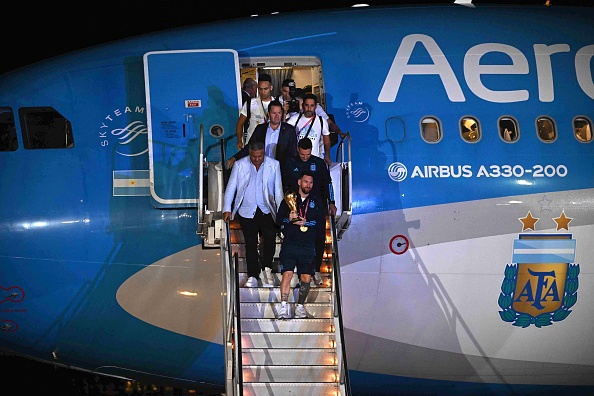 Le capitaine et attaquant Lionel Messi tient le trophée de la Coupe du Monde de la FIFA 2022 à son arrivée à l'aéroport international d'Ezeiza à Buenos Aires, Argentine, le 20 décembre 2022.  (Photo : LUIS ROBAYO/AFP via Getty Images)