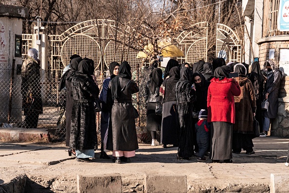 Des étudiantes afghanes arrêtées par le personnel de sécurité taliban se tiennent près d'une université à Kaboul, le 21 décembre 2022.  (Photo : WAKIL KOHSAR/AFP via Getty Images)