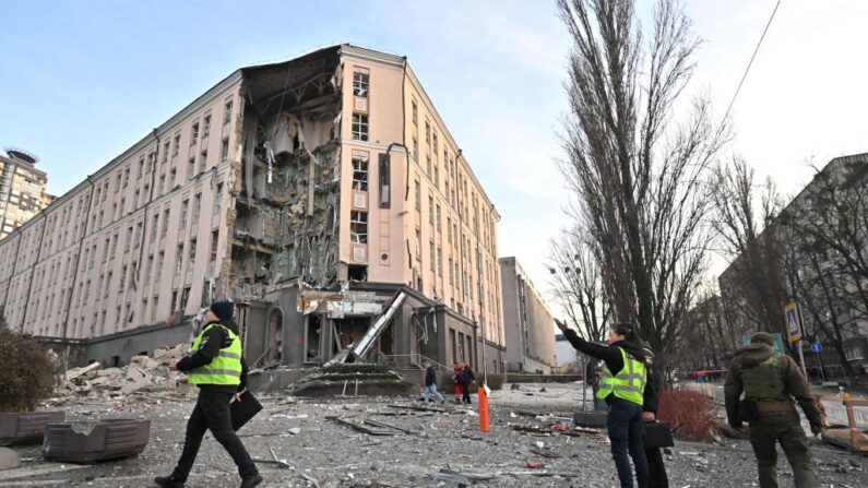 Des sauveteurs et des policiers travaillent au pied d'un hôtel partiellement détruit par une frappe russe, dans le centre de Kiev, le 31 décembre 2022. (Photo: SERGEI SUPINSKY/AFP via Getty Images)