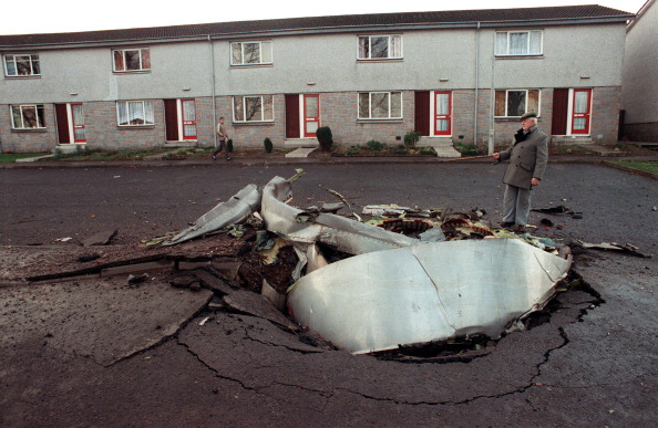 Un habitant de Lockerbie, se tient près de l'un des quatre moteurs du  747 de Pan Am qui s'est écrasé le 22 décembre dans le village écossais.  (Photo : ROY LETKEY/AFP via Getty Images)