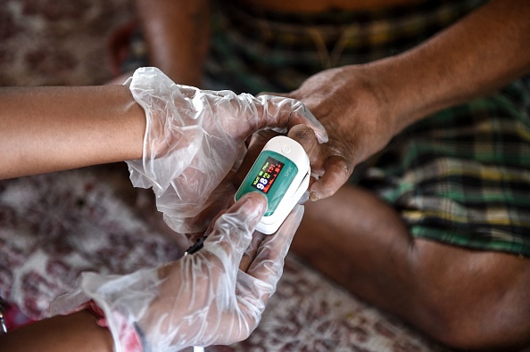 Un bénévole utilise un oxymètre pour contrôler un patient infecté par la lèpre au centre de réhabilitation Gandhi Leprosy Seva Sangh, à Ahmedabad, Inde. (Photo : SAM PANTHAKY/AFP via Getty Images)